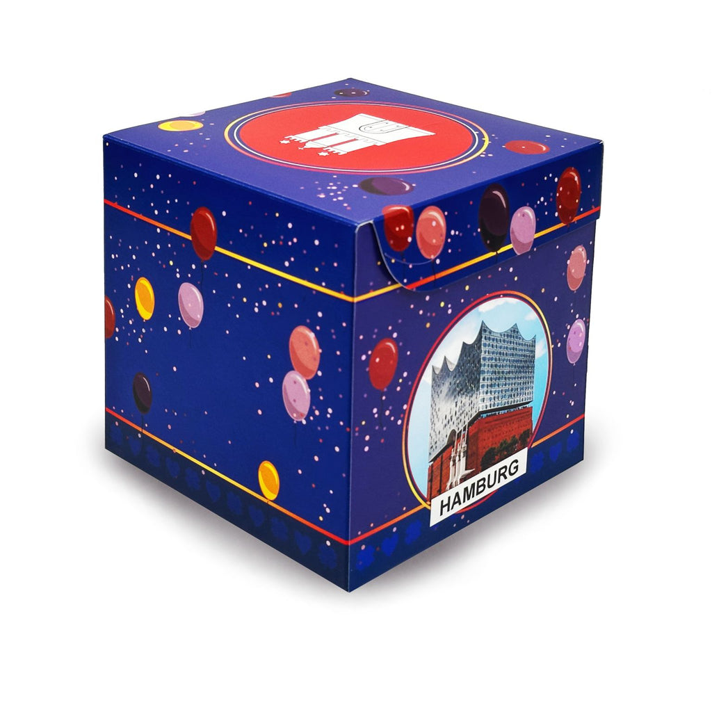 Rätsel-Geschenkbox Geburtstag im blauen Ballon-Design mit Hamburg-Motiv der Elbphilharmonie auf der Seite und Schriftzug ‚Hamburg‘.