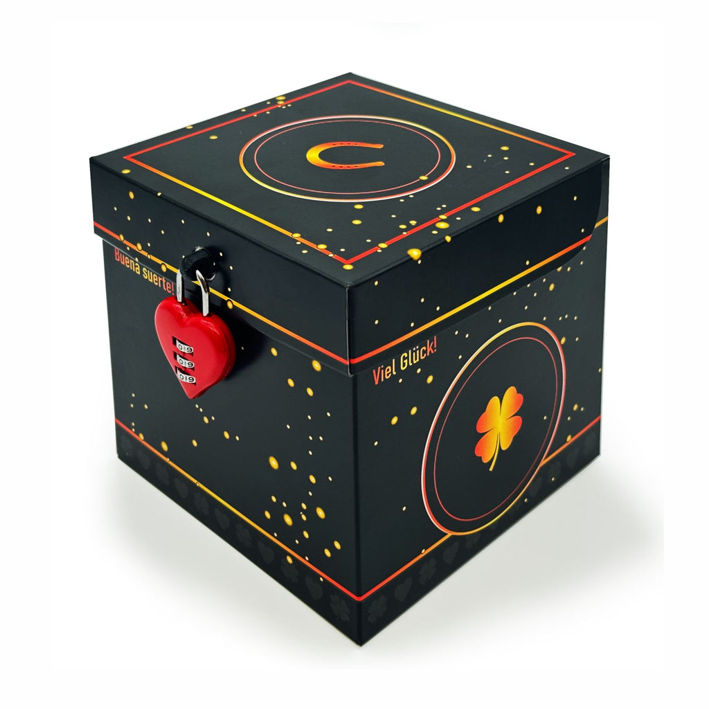 Geschlossene Rätselbox Glück in Schwarz mit goldenen Sprenkeln, Kleeblatt-Design auf der Seite (Viel Glück!), Hufeisen auf dem Deckel und rotem Herz-Zahlenschloss.