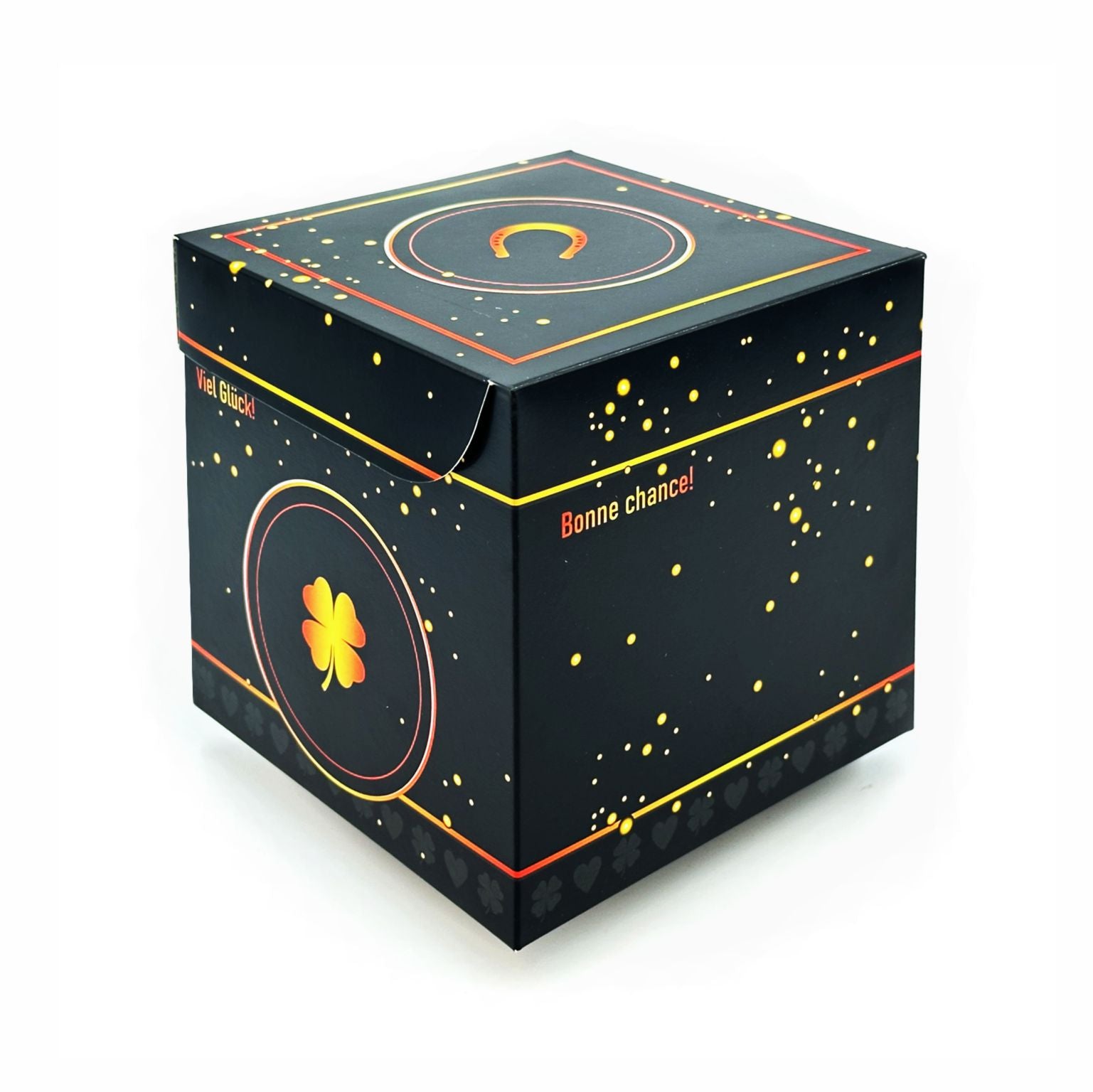 Geschlossene Rätselbox Glück in Schwarz mit goldenen Sprenkeln und Kleeblatt-Motiv (Viel Glück) auf der Seite und Hufeisen auf dem Deckel auf weißem Hintergrund.