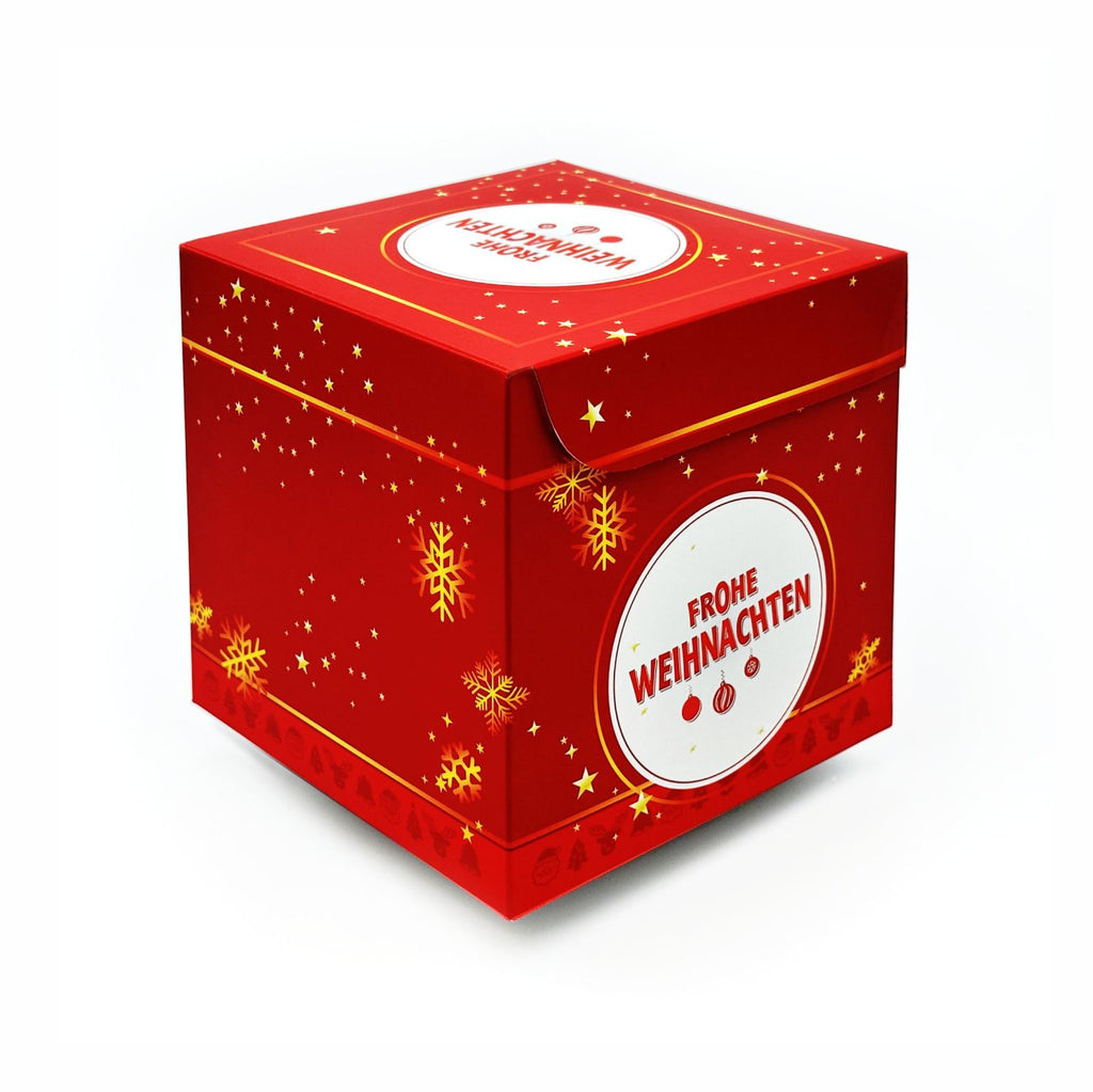 Geschlossene Rätselbox Weihnachten in Rot mit goldenen Stern- und Schneeflockenmotiven und rundem Motiv mit Schriftzug ‚Frohe Weihnachten‘.