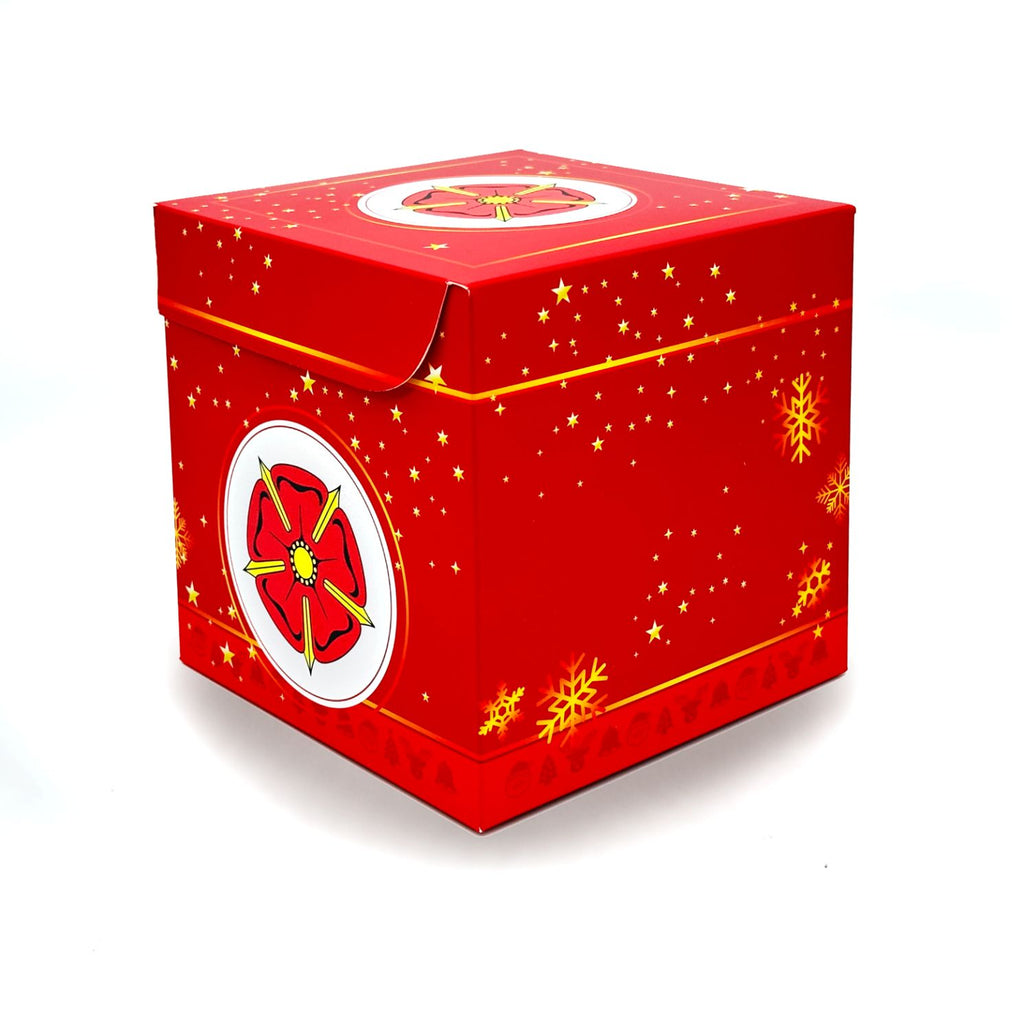 Seitliche Ansicht der roten Rätselbox Weihnachten Lippische Rose mit Schneeflocken- und Sternmotiv, freigestellt auf weißem Hintergrund.