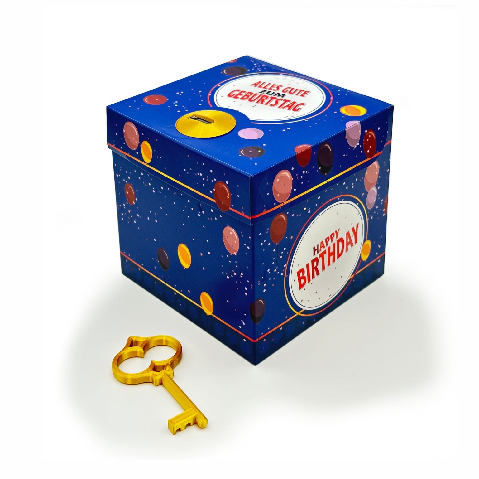 Geschlossene Schlossbox zum Geburtstag im blauen Ballon-Design mit rundem Schriftzug ‚Happy Birthday‘, dekorativer goldener Schlüssel liegt vor der Box.