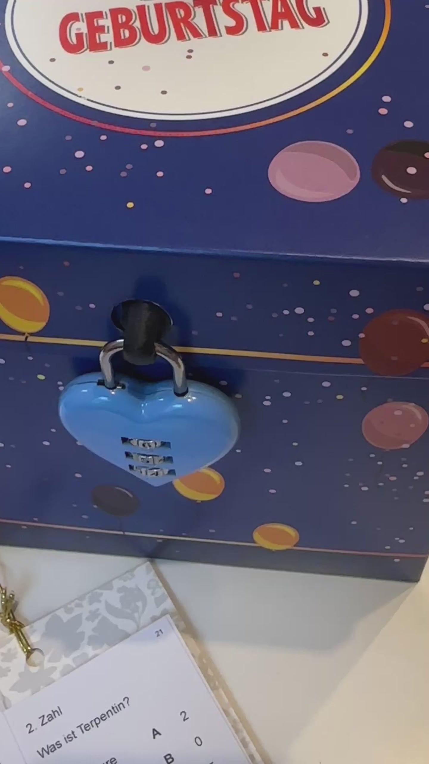 Das blaue Herzschloss (Zahlenschloss) an der Rätselbox Geburtstag wird geöffnet.